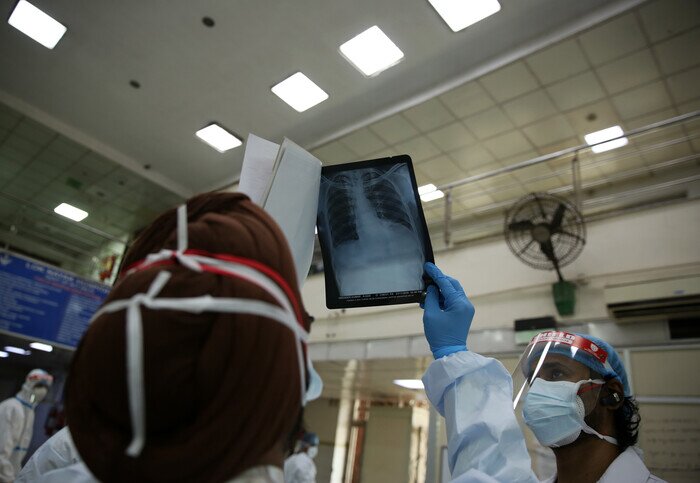 在一間有宗教背景的醫院的小教堂內,一名前綫醫生正在低頭禱告。