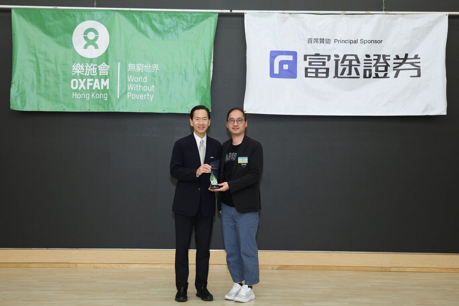 樂施毅行者督導小組召集人陳智思頒發樂施毅行者2024紀念品予首席贊助富途證券國際(香港)有限公司董事總經理謝志堅。